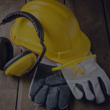 A photograph of a hard hat, protective gloves and ear defenders