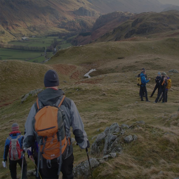 A photograph showing a group of people hiking across hills