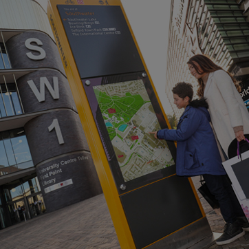 A photograph showing a mother and child using a wayfinder totem in Southwater